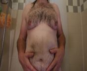 Close up of obese hairy man torso while standing naked in bathtub rubbing or massaging his belly from nude big belly aunty